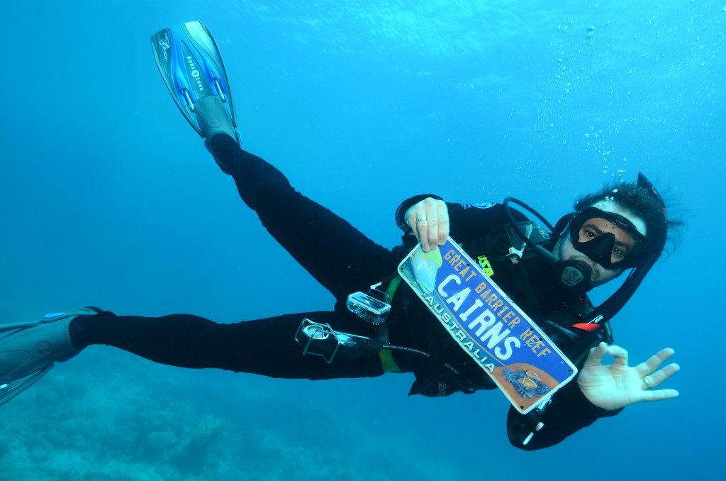 a person in scuba gear holding a sign underwater