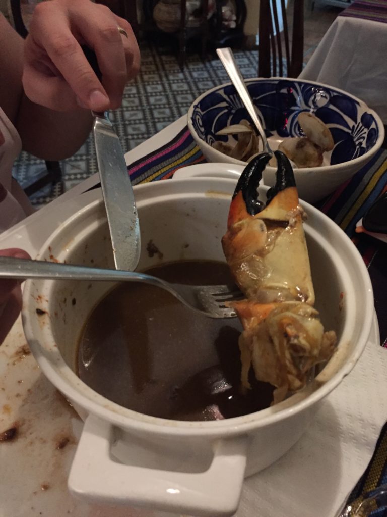 a bowl of soup with a crab claw in it