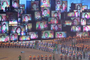 a group of people in front of large screens