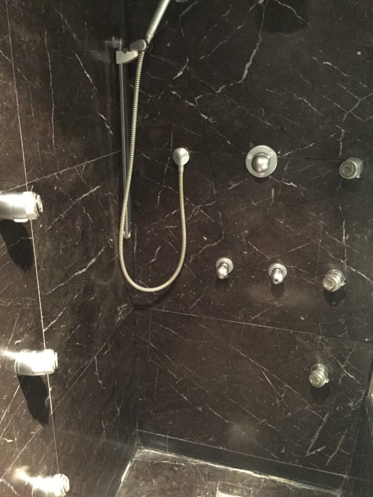 a shower with a hose and knobs