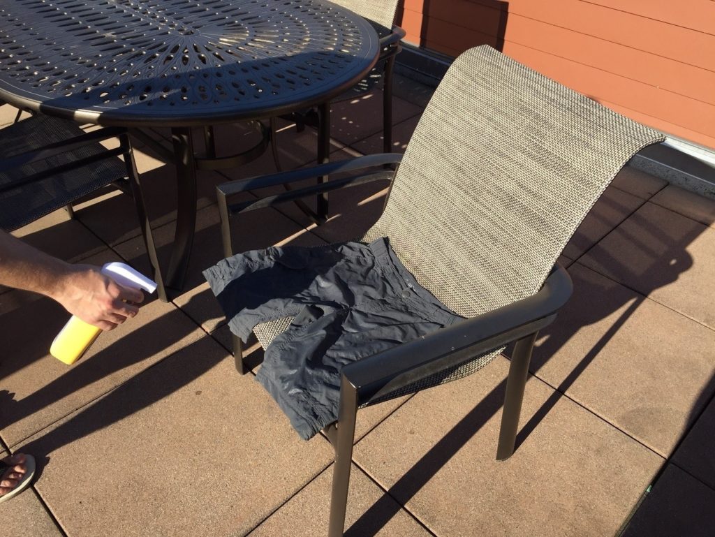 a person holding a spray gun to a chair