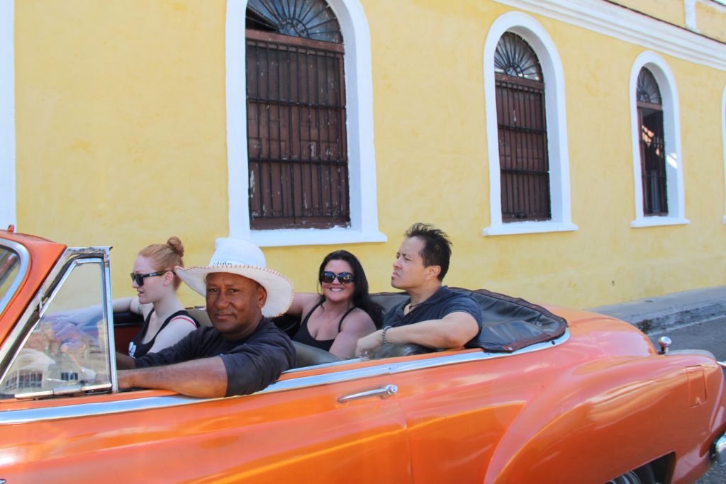 a group of people in a convertible car