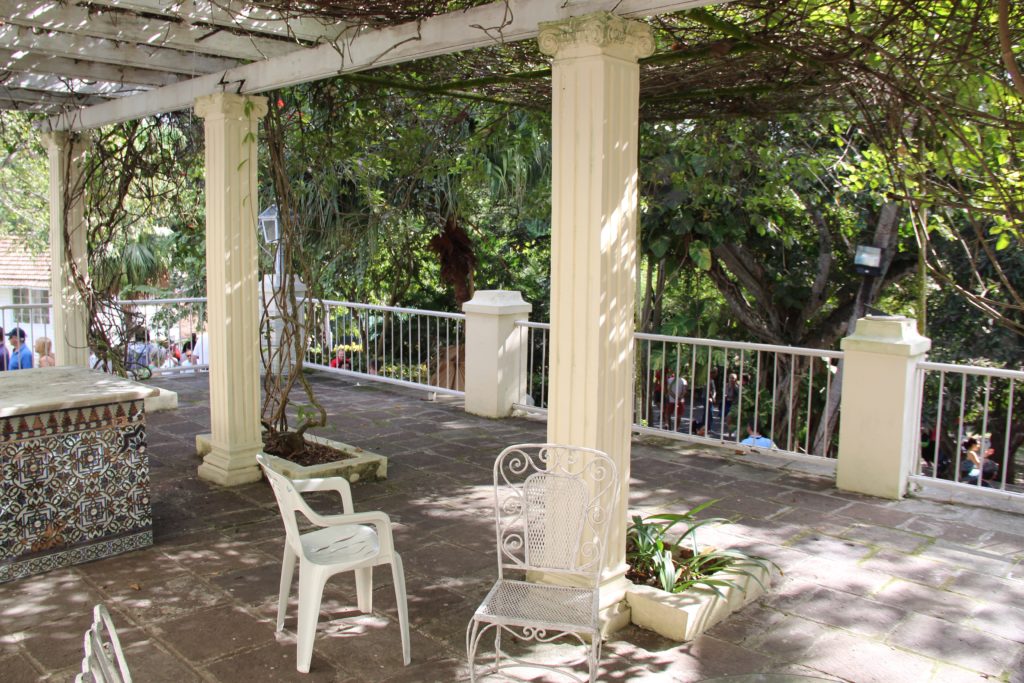 a white patio with white pillars and chairs
