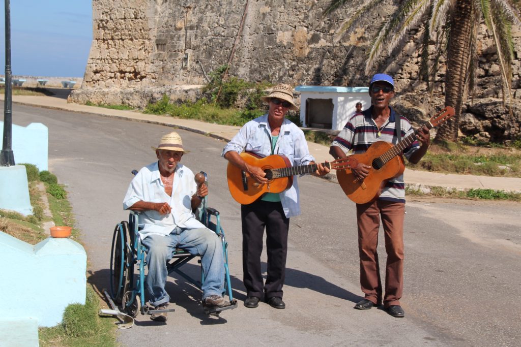 a group of men playing guitars on a street