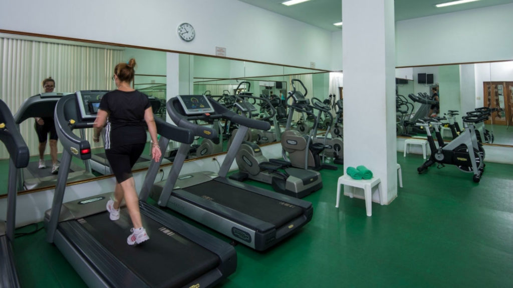 a woman walking on treadmills in a gym