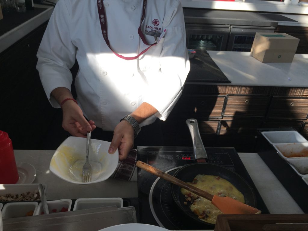 a person in a white coat cooking food