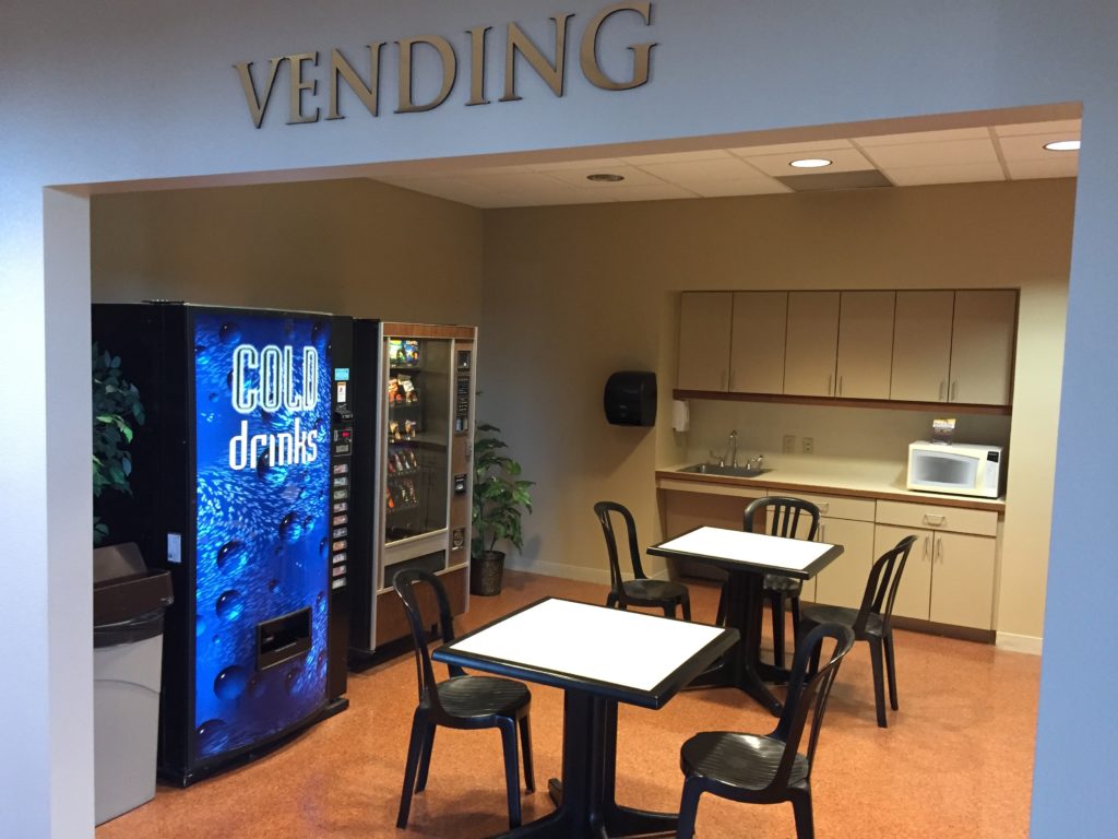 a vending machine and tables in a room