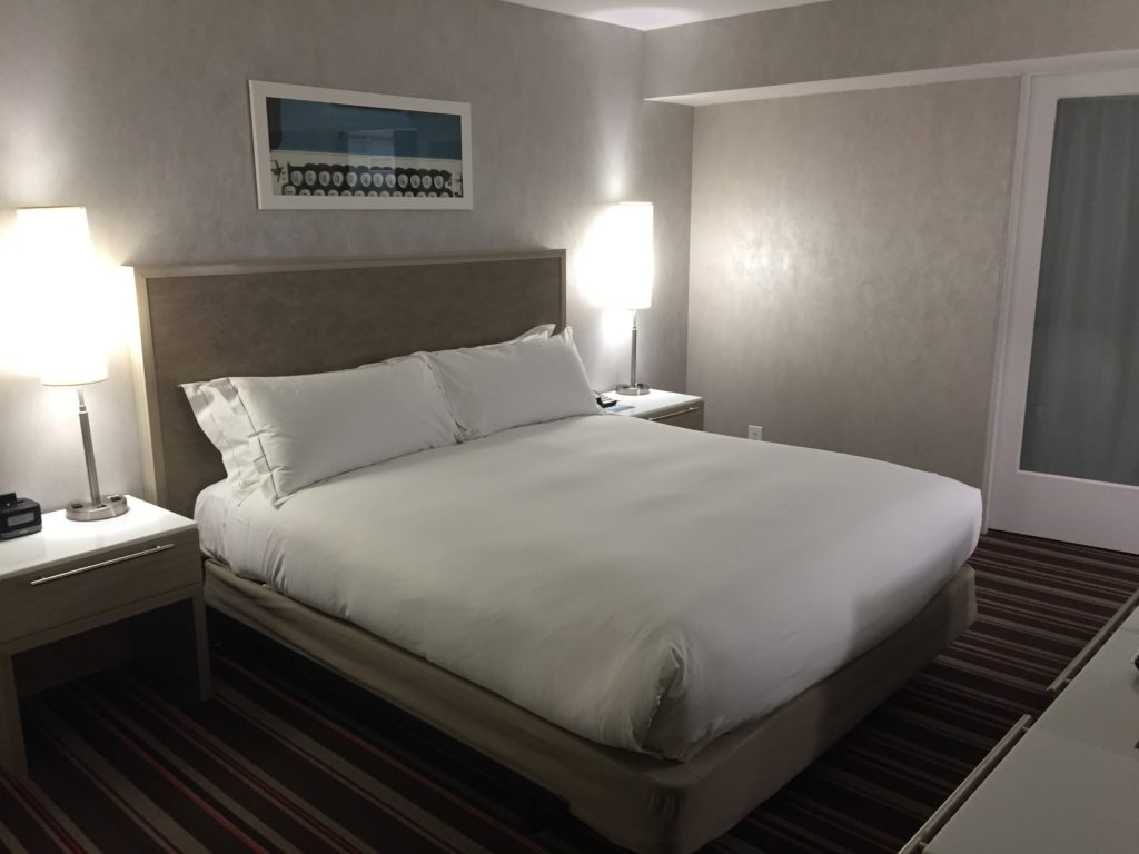 a bed with white sheets and a lamp