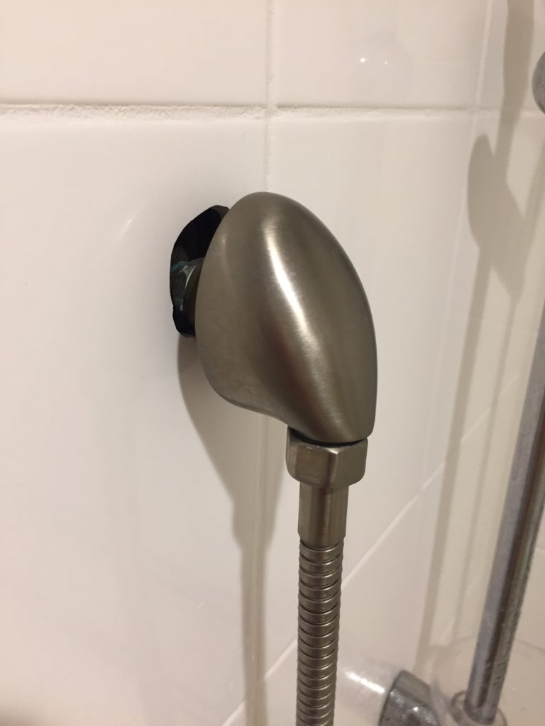 a shower head with a hole in the wall