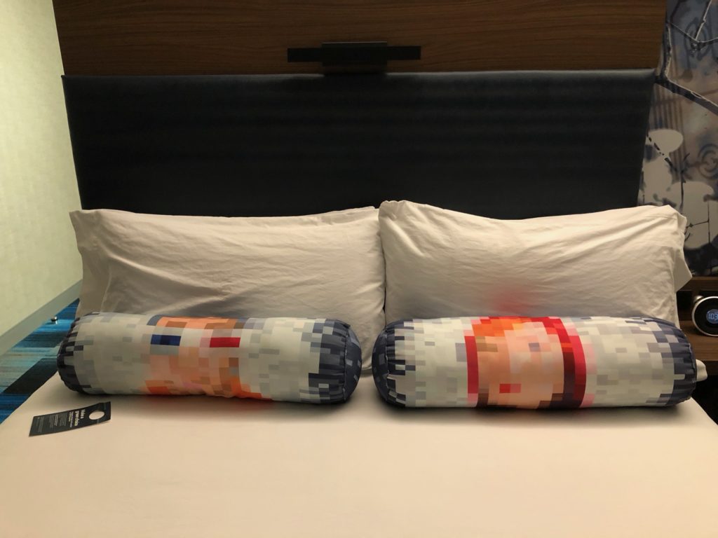 a bed with pillows and a pair of glasses