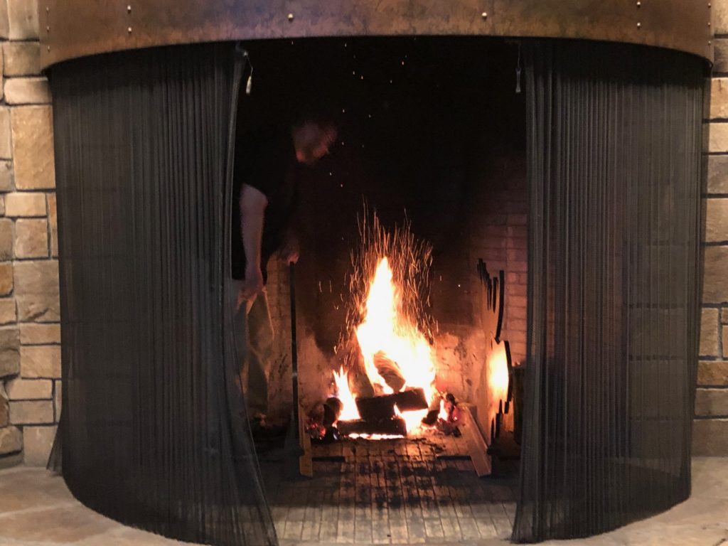 a man standing in front of a fireplace