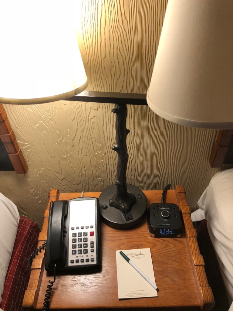 a telephone and a lamp on a night stand