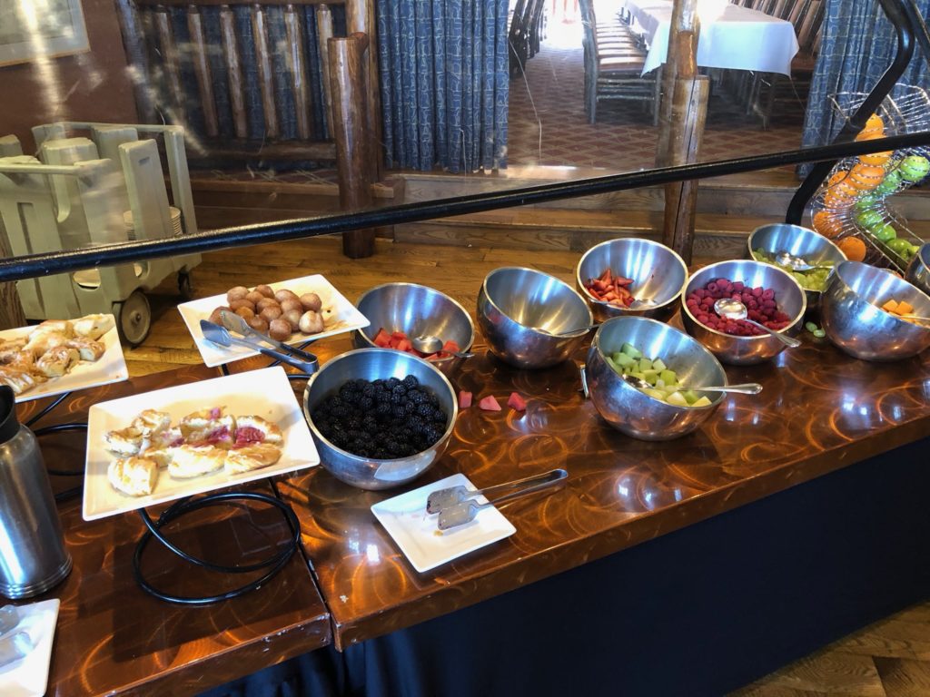 a buffet table with bowls of fruit and desserts