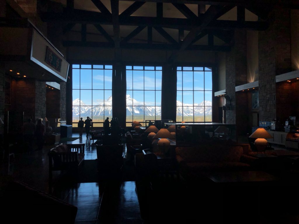 a room with a large window and mountains in the background