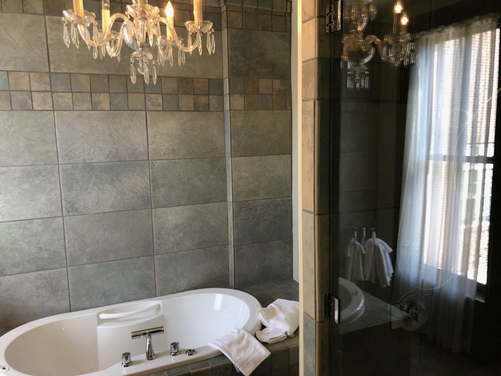 a bathroom with a bathtub and a chandelier