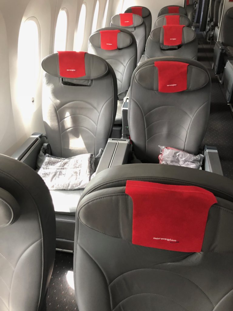 a row of grey and red seats on an airplane