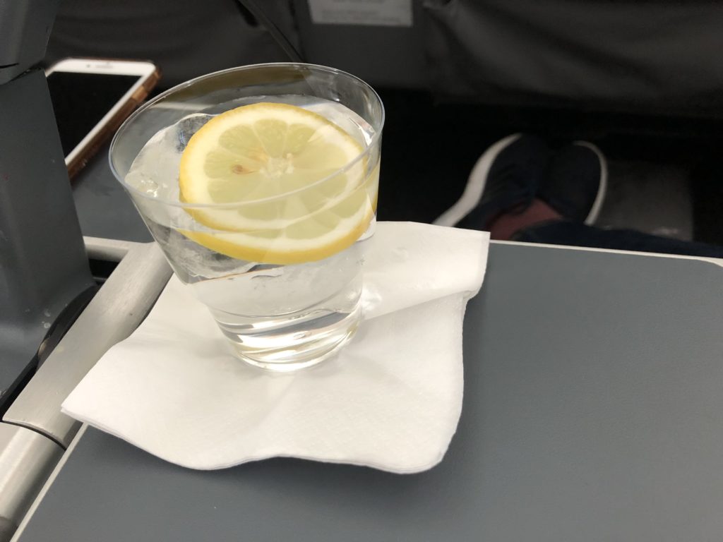 a glass of water with a lemon slice on a napkin