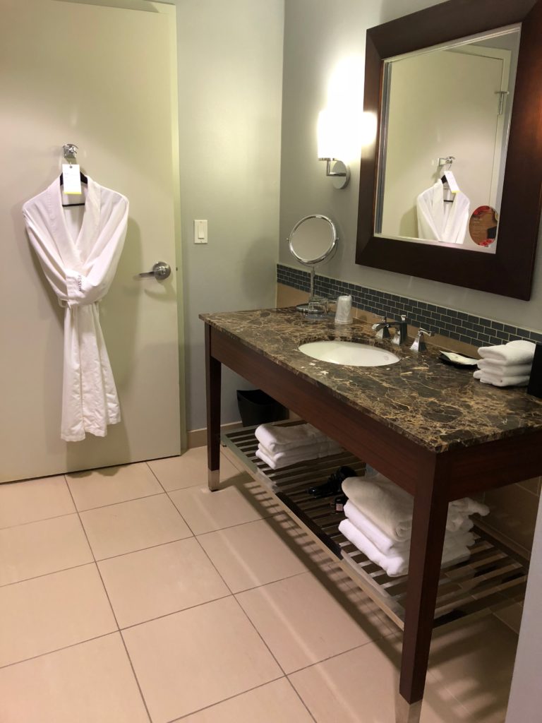 a bathroom with a white robe and a mirror