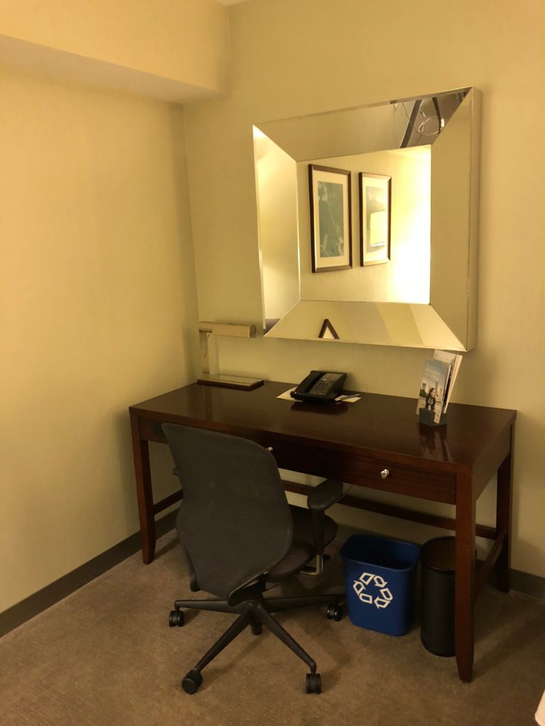 a desk with a chair and a mirror