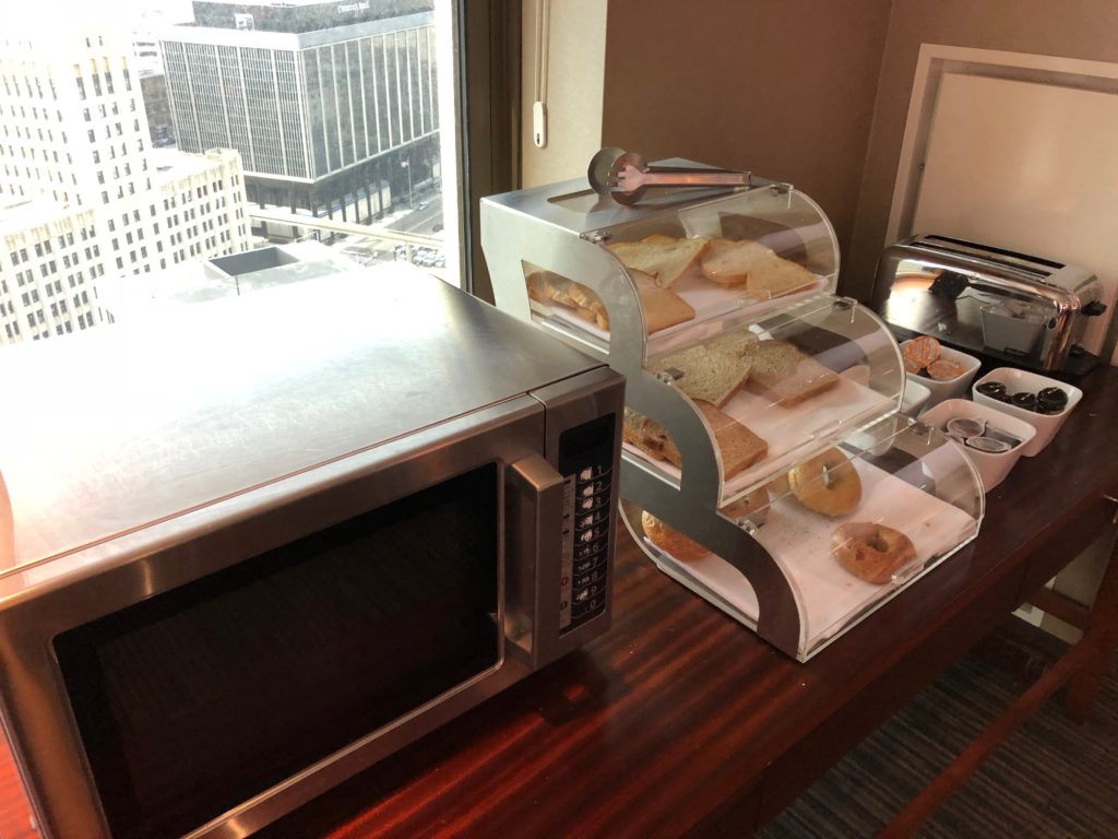 a food in a glass case next to a microwave