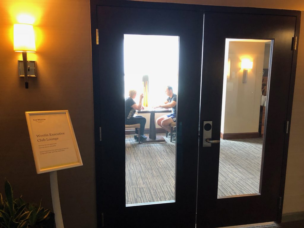 a door with glass and a couple of people sitting at a table