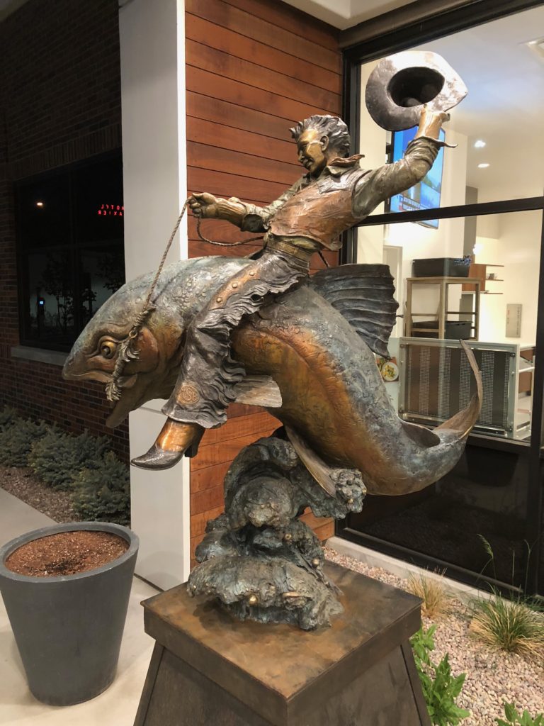 a statue of a man riding a fish