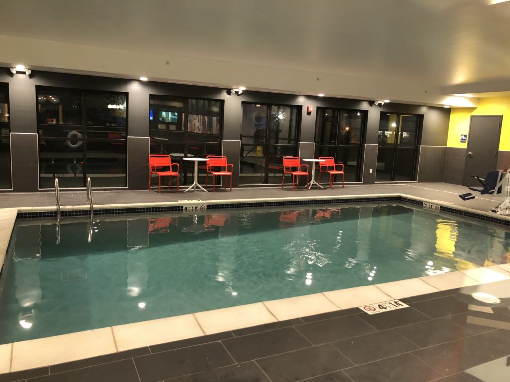 a pool with red chairs and tables