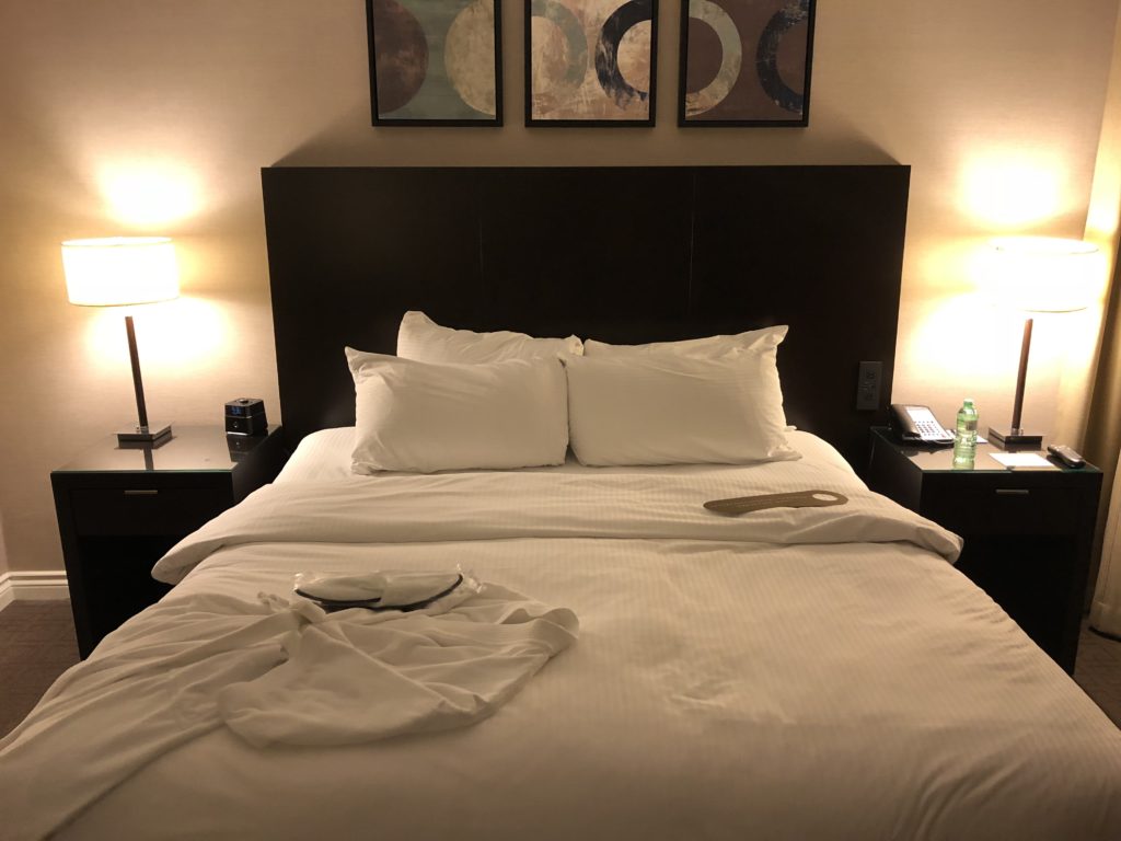 a bed with white sheets and pillows