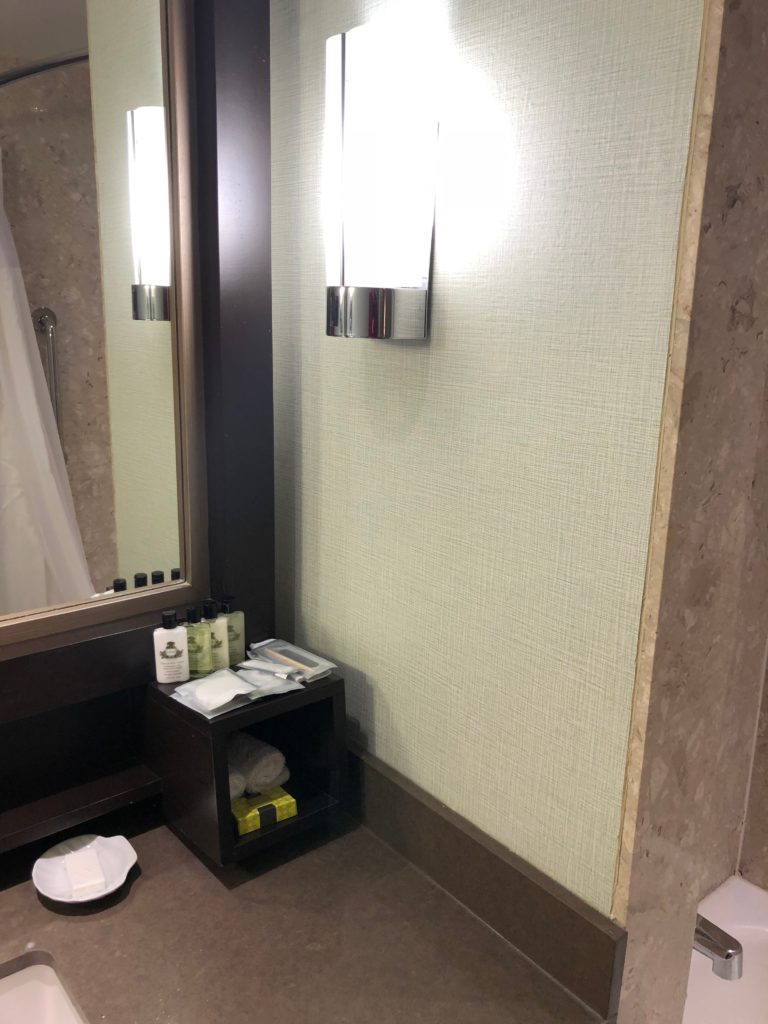 a bathroom with a mirror and a shelf