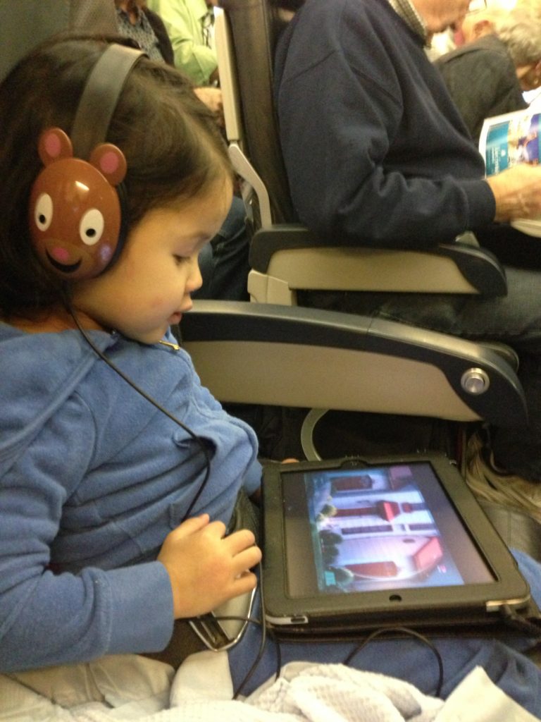 a child wearing headphones and using a tablet