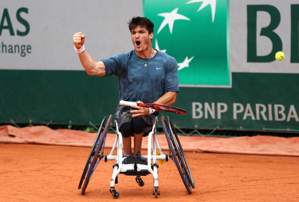a man in a wheelchair holding a tennis racket
