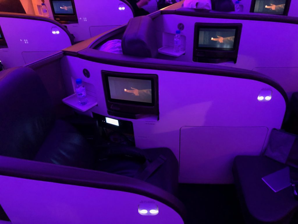 a group of people in a row of seats with monitors