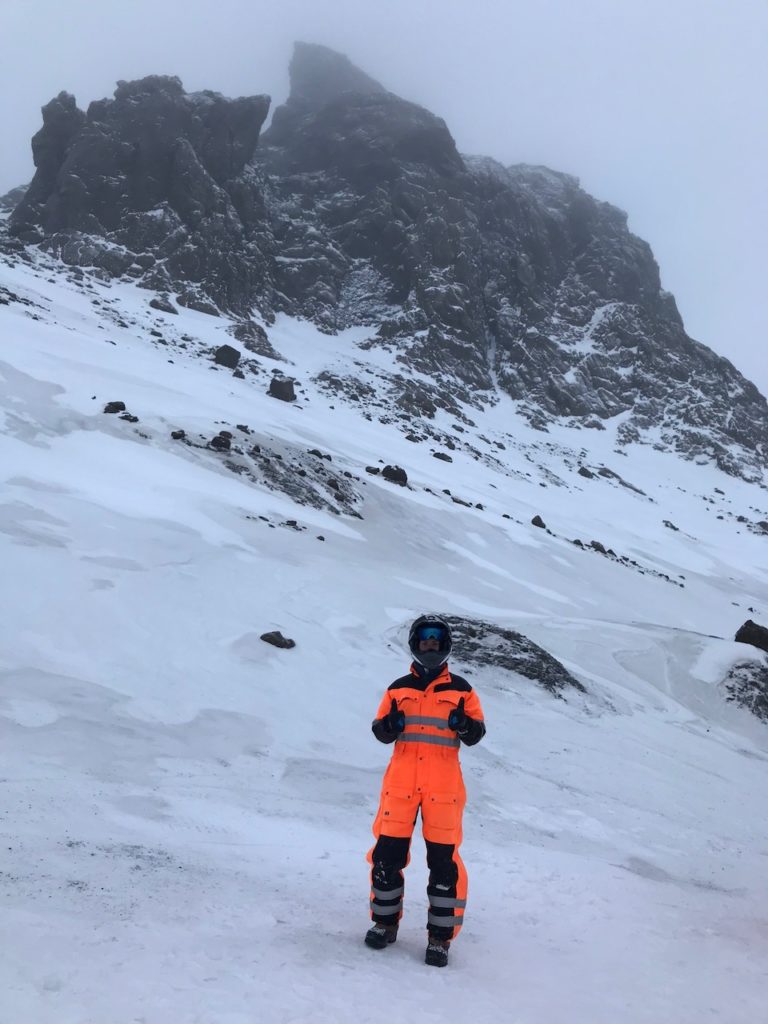 a person in an orange jumpsuit standing in the snow