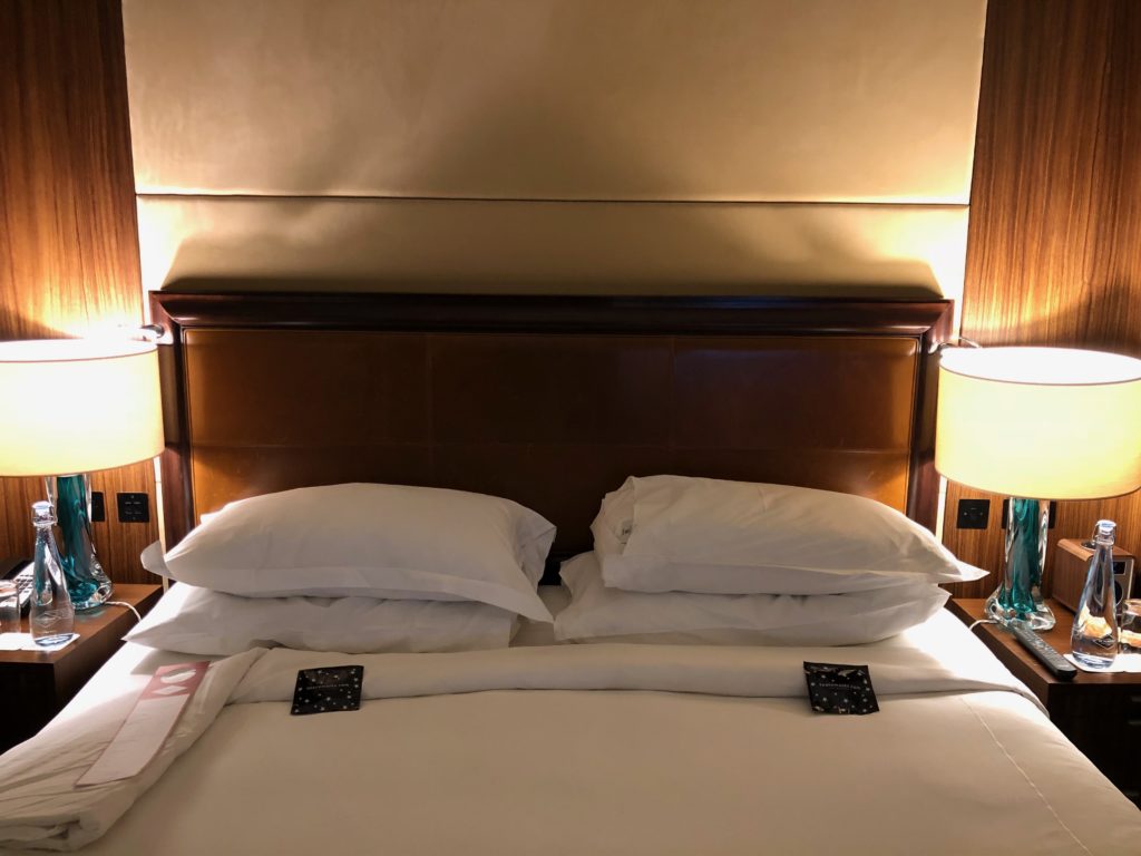 a bed with white pillows and a lamp