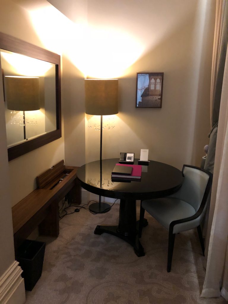 a table with a lamp and a mirror