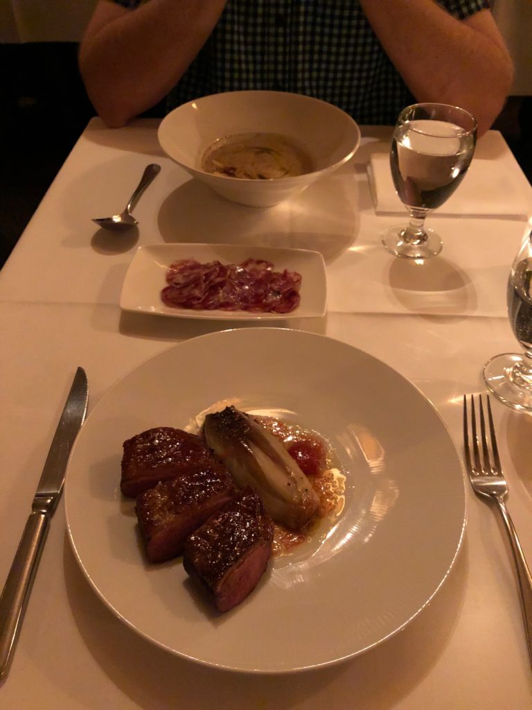 a plate of meat and a bowl of food on a table