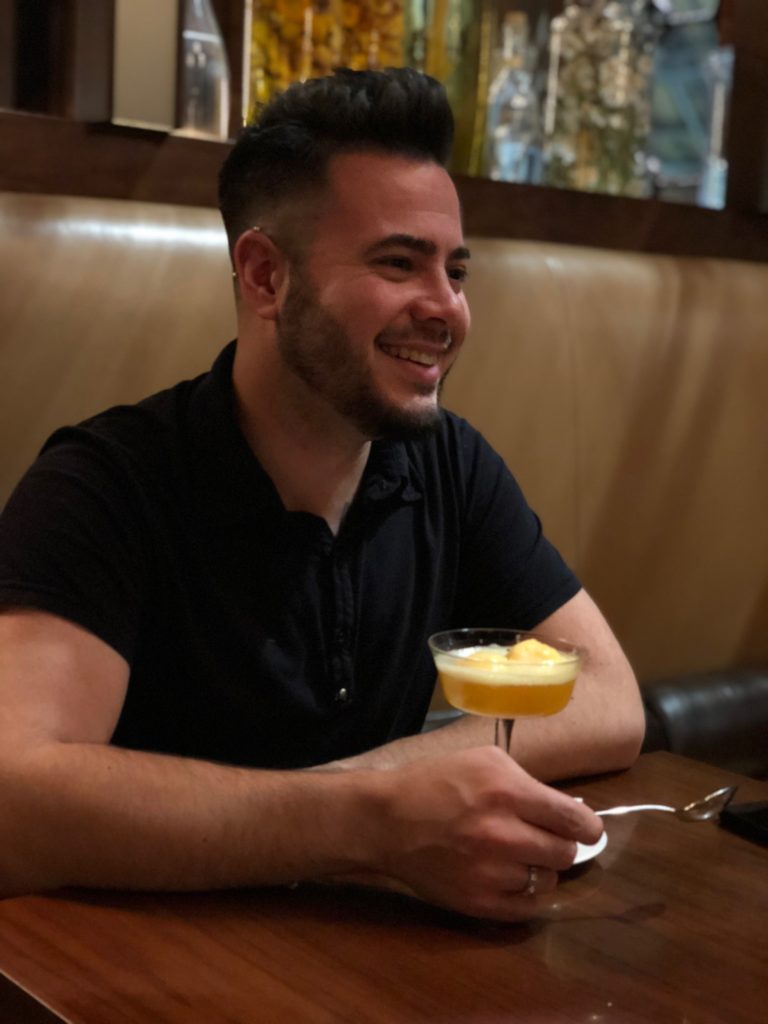 a man sitting at a table with a drink