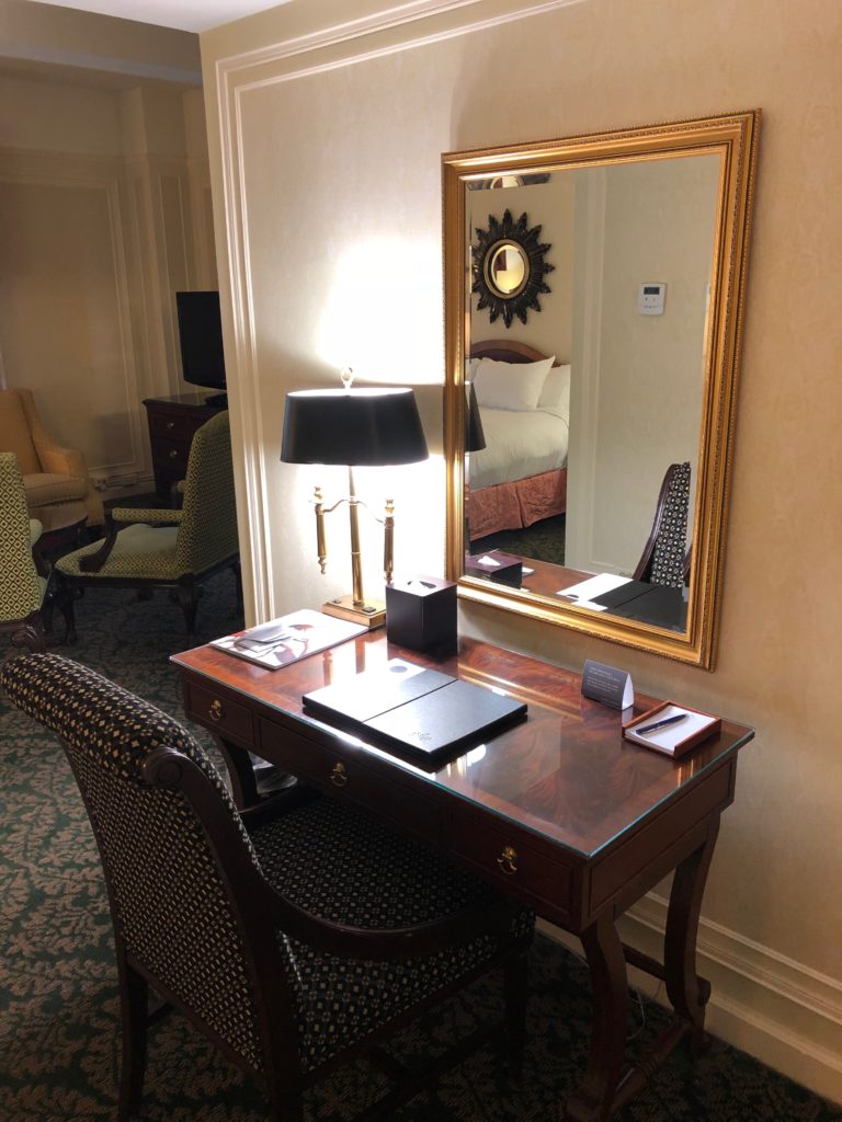 a desk with a lamp and a mirror in a room