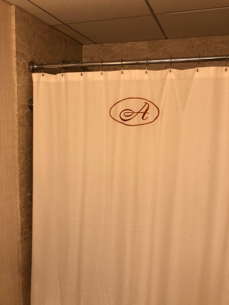 a shower curtain with a letter on it