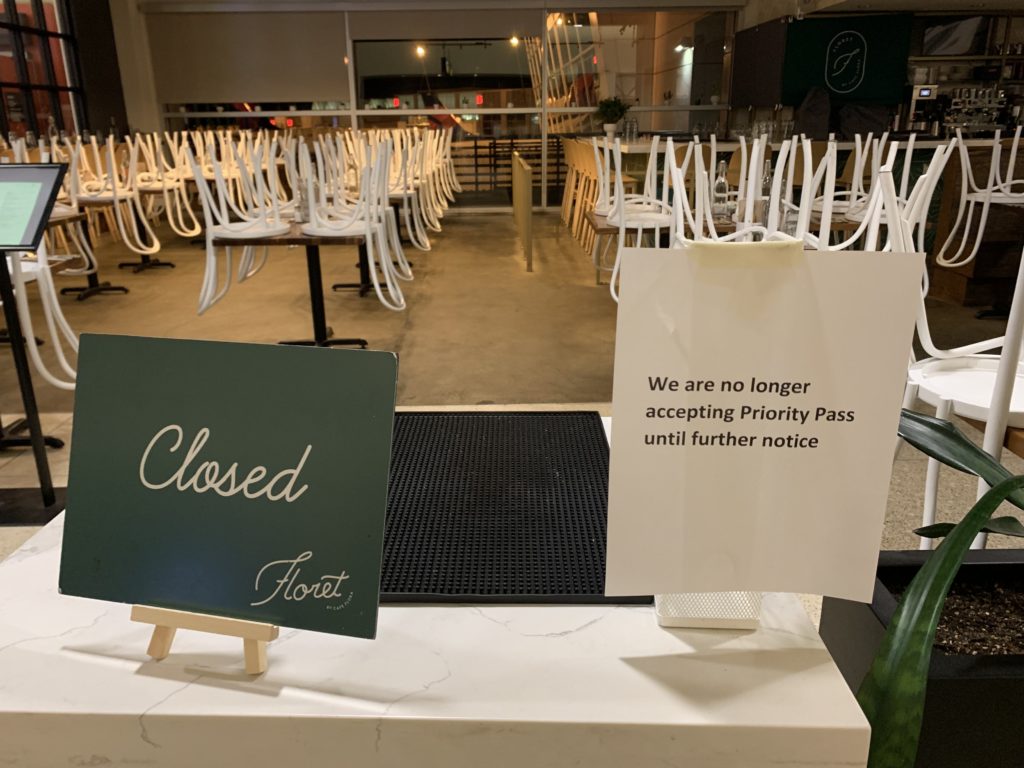 a sign on a counter with chairs in the background