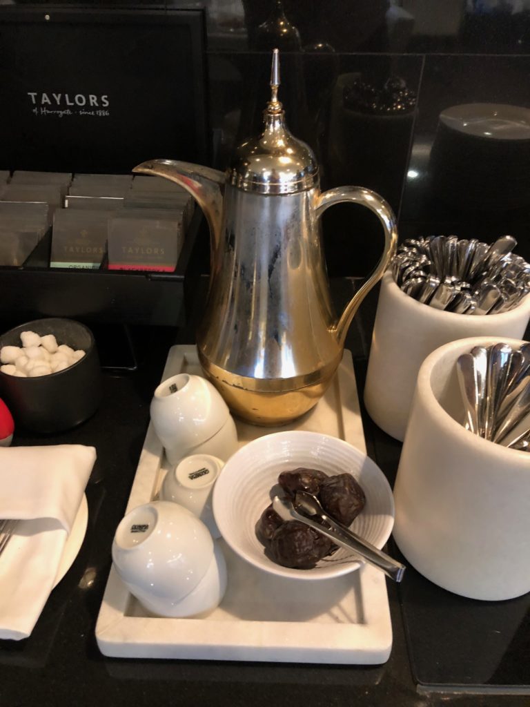 a silver coffee pot and bowl of dates on a tray