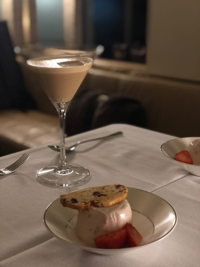 a dessert on a plate with a drink in the background