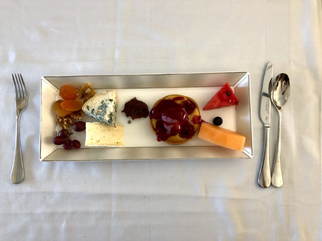 a plate of food with fruit and a spoon