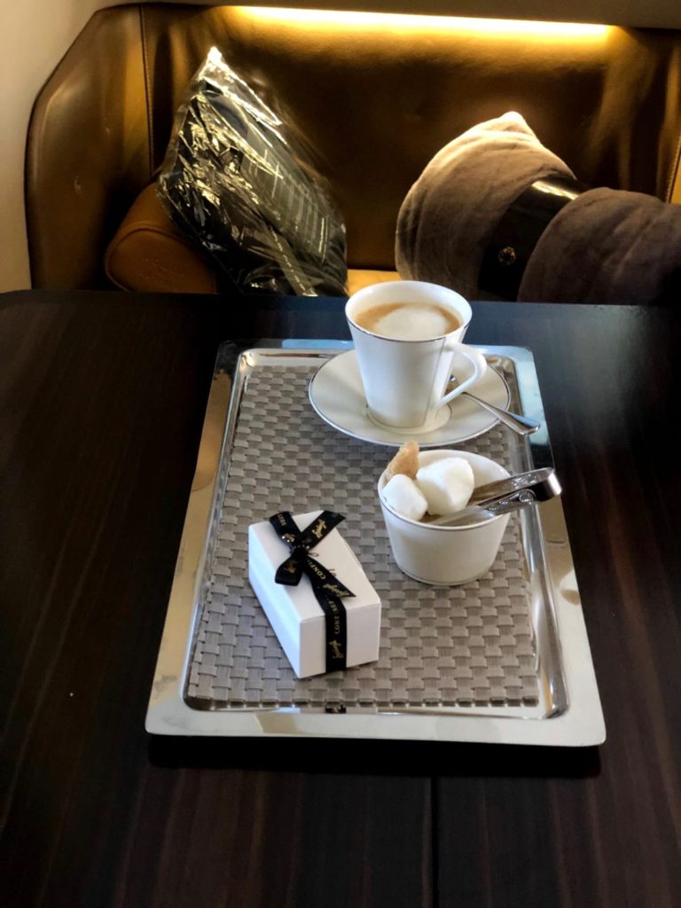 a tray with a cup of coffee and a small box on it