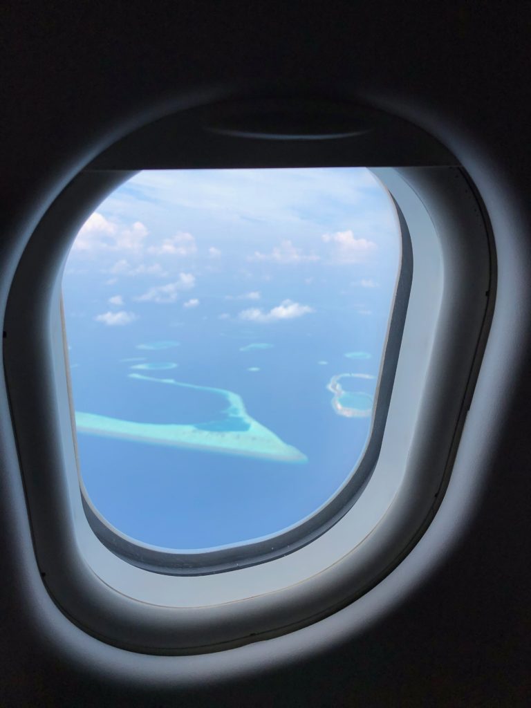 an airplane window with a view of the ocean and islands