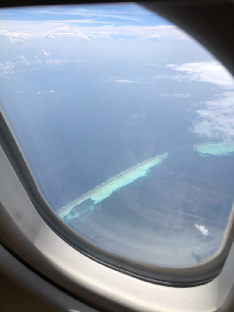 an airplane window with a view of the ocean and land