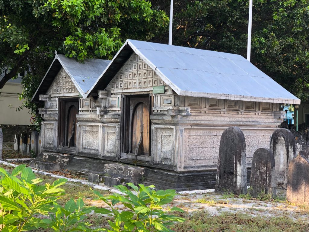 a stone building with a roof and a cemetery