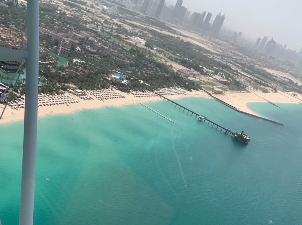 a beach with a pier and buildings in the background