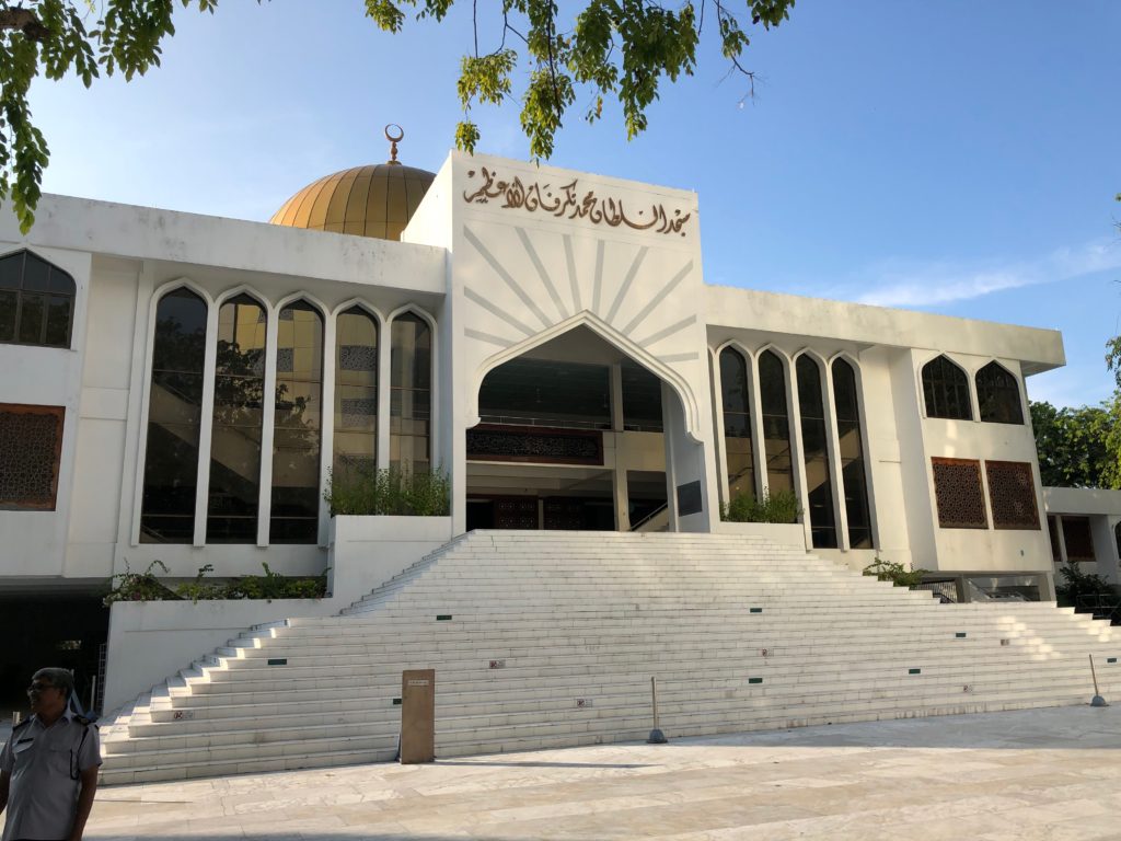 a white building with a dome and a gold roof