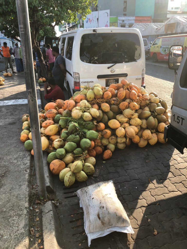 a pile of fruits on the side of a road